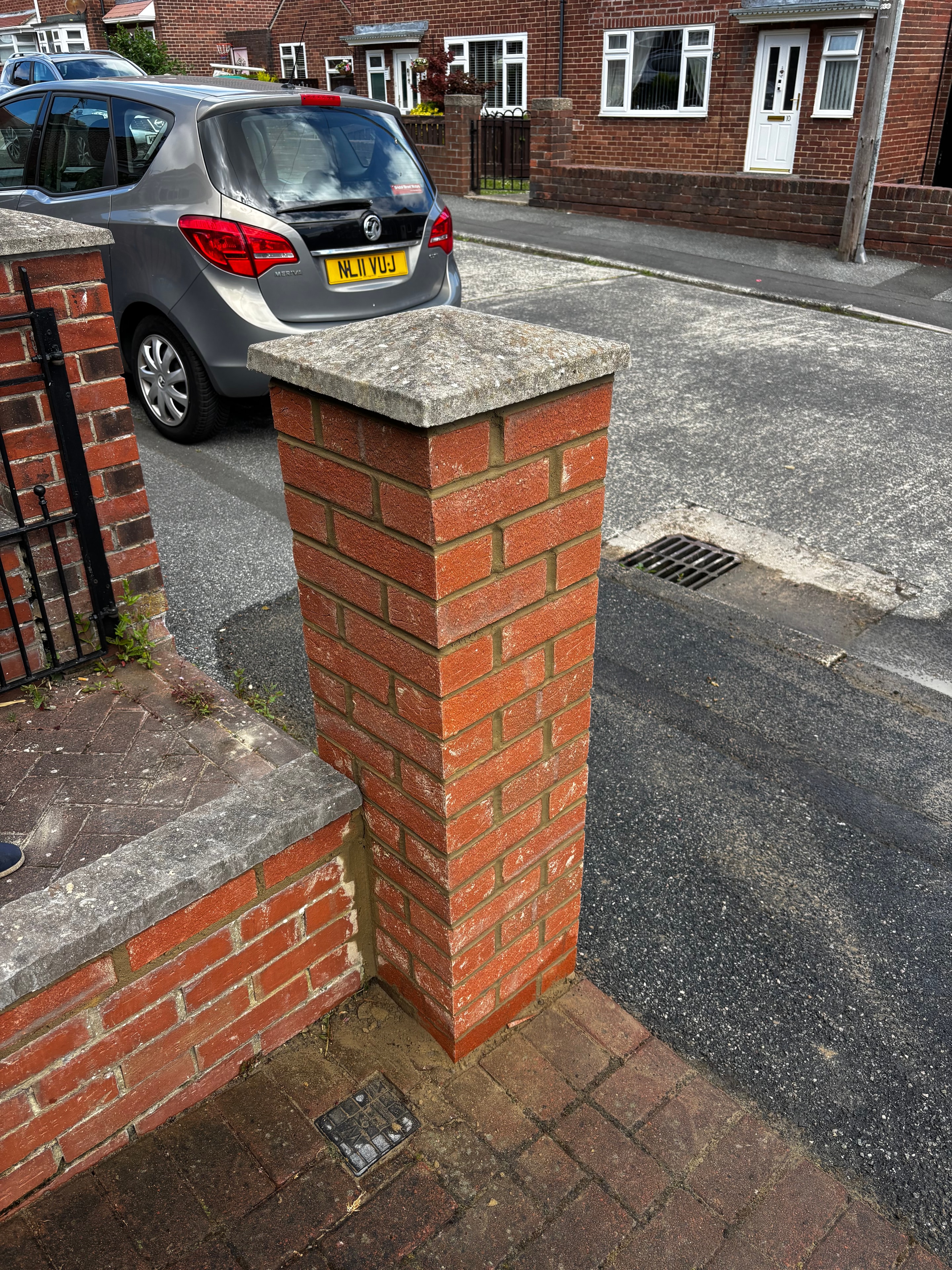 Bricklayer building a red brick wall